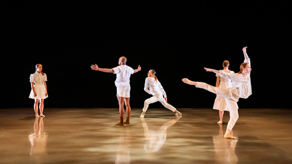five dancers clad in white occupy seperate areas of the stage, each involved in their own world